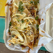 Loaded Pig Nachos · Tortilla chips, Hawaiian style pulled pork, cheese, tsunami sauce, green onion & furikake